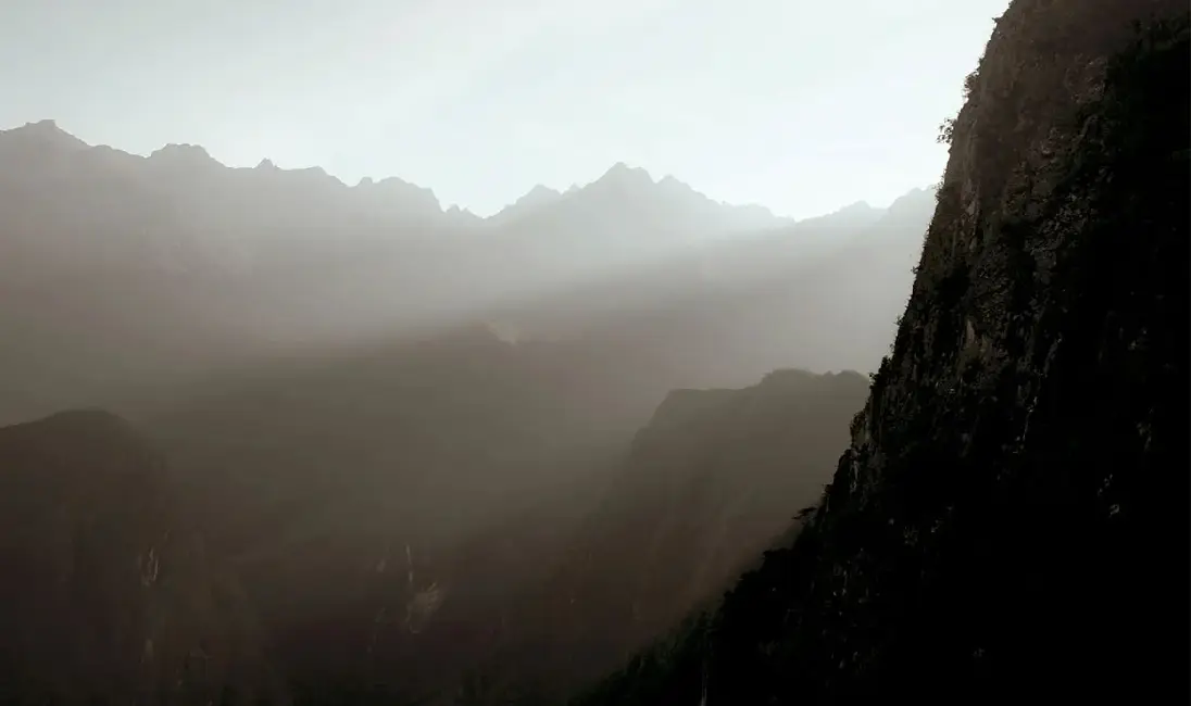 A dark, atmospheric shot of Machu Picchu on a foggy day.